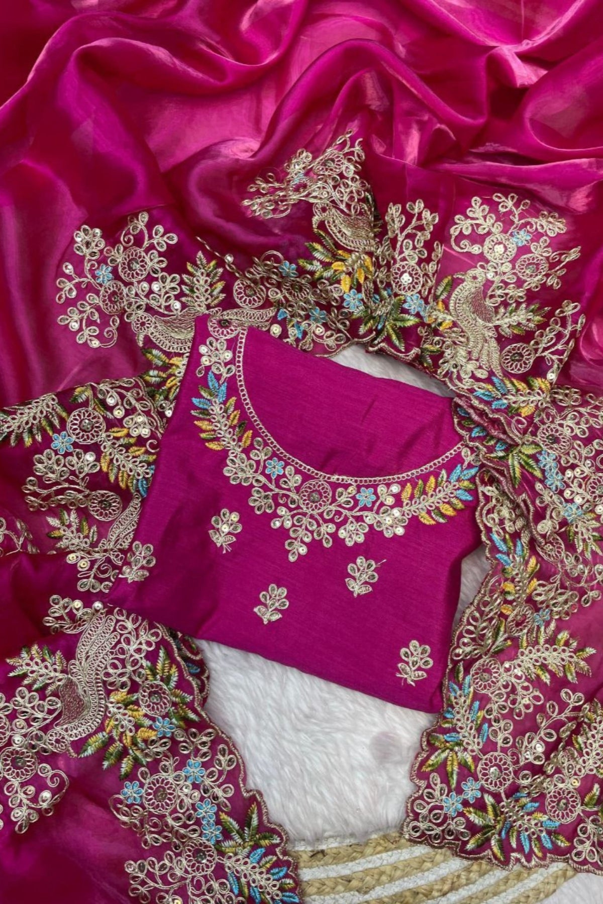 Pink blouse with intricate gold embroidery on a pink fabric background